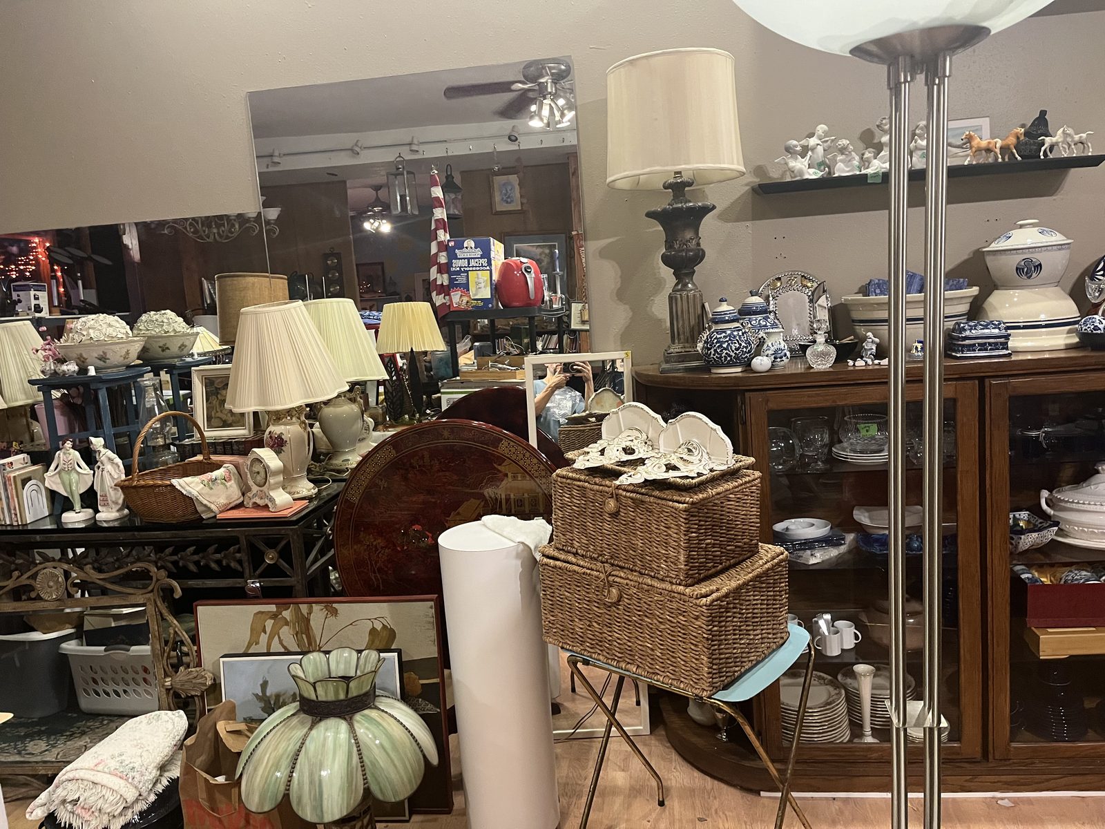 Table lamps, wicker sewing baskets and blue and white porcelain on an oak china cabinet at Simple Treasures